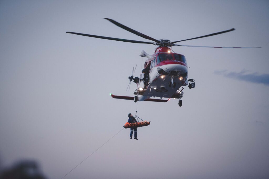 A Helicopter using steel wire rope to hoist and rescue someone.